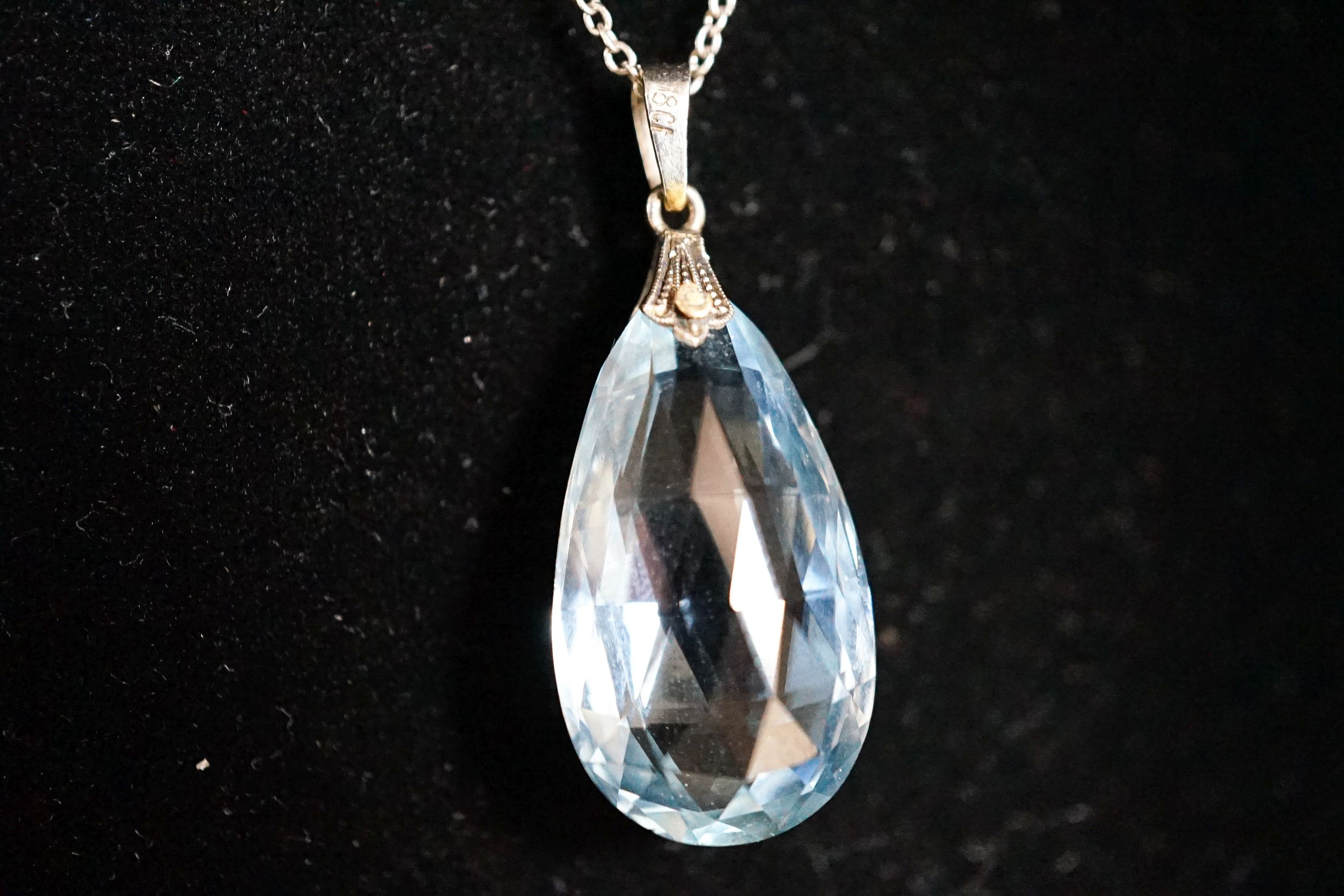 An 18ct mounted facetted pear cut aquamarine set pendant, 33mm, on a 375 white metal fine link chain, 45cm, gross weight 5.2 grams.